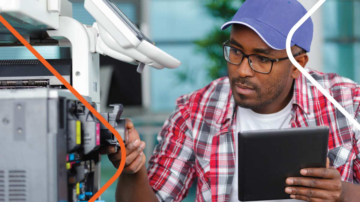 Man in blue hat servicing copy machine